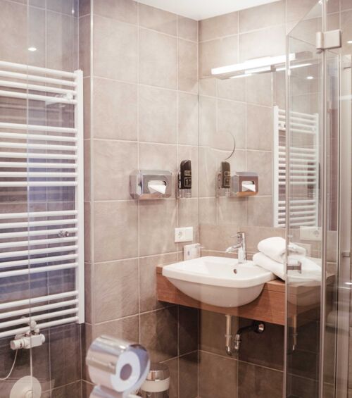 Modern bathroom with glass shower screen, heated towel rail and sink