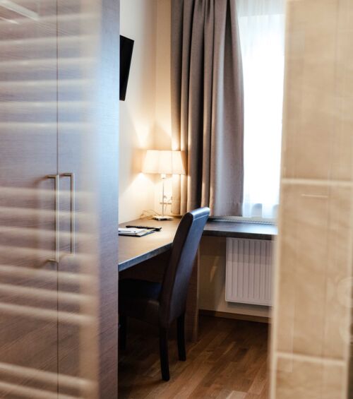 A desk with reading lamp in the bright single room of the 4-star hotel Kirchbichl