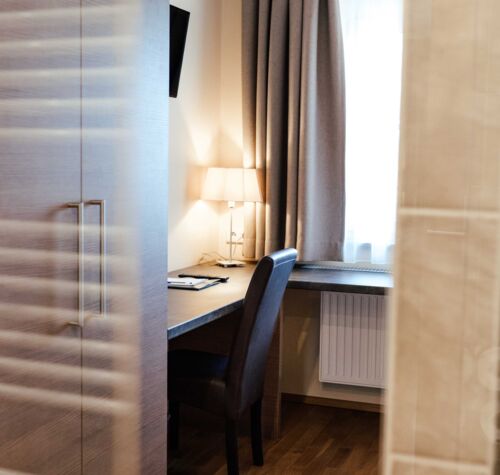 Ein Schreibtisch mit Leselampe im hellen Einzelzimmer des 4-Sterne hotels Kirchbichl