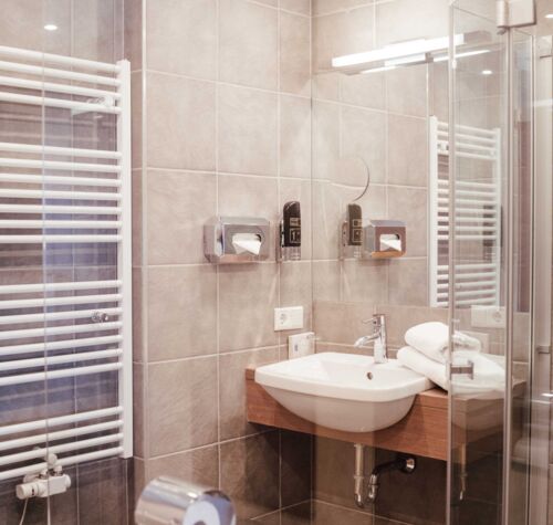 Modern bathroom with glass shower screen, heated towel rail and sink