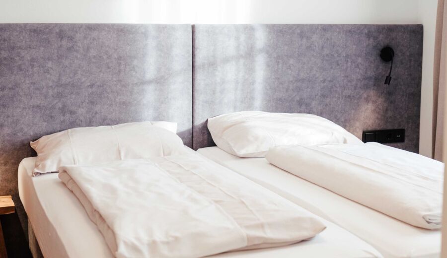 Das frisch bezogene Doppelbett im Doppelzimmer Gästhaus im 4-Sterne-Hotel Kirchbichl