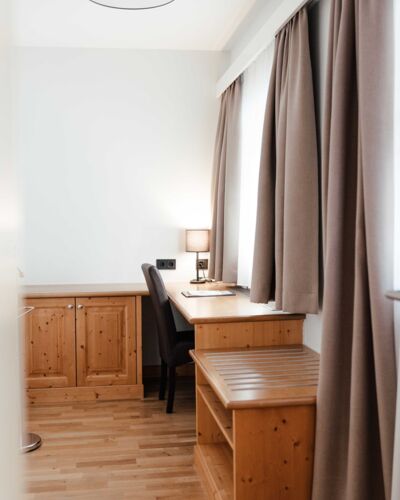 The double room in the guest house with a desk in front of the window at Landgasthof Kirchbichl