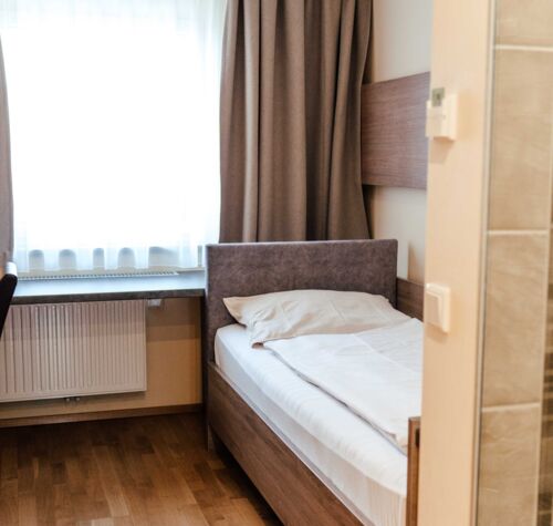 Einzelbett im Einzelzimmer mit großem Fenster im Hotel Kirchbichl